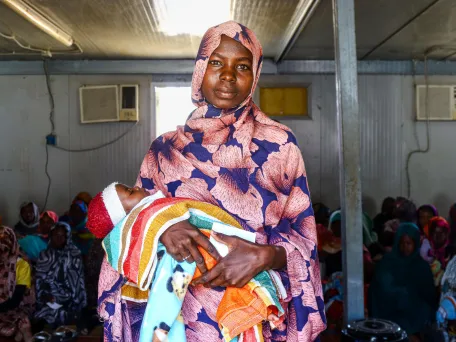 Matka s dítětem ve zdravotním centru tábora Kalma. Súdán, 2024. 