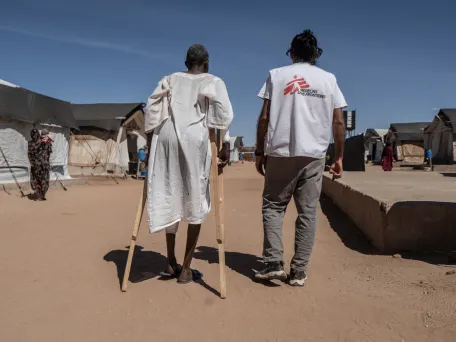 Zraněný muž a lékařský koordinátor Lékařů bez hranic před nemocnicí. Súdán, 2026. Foto: Giles Clarke