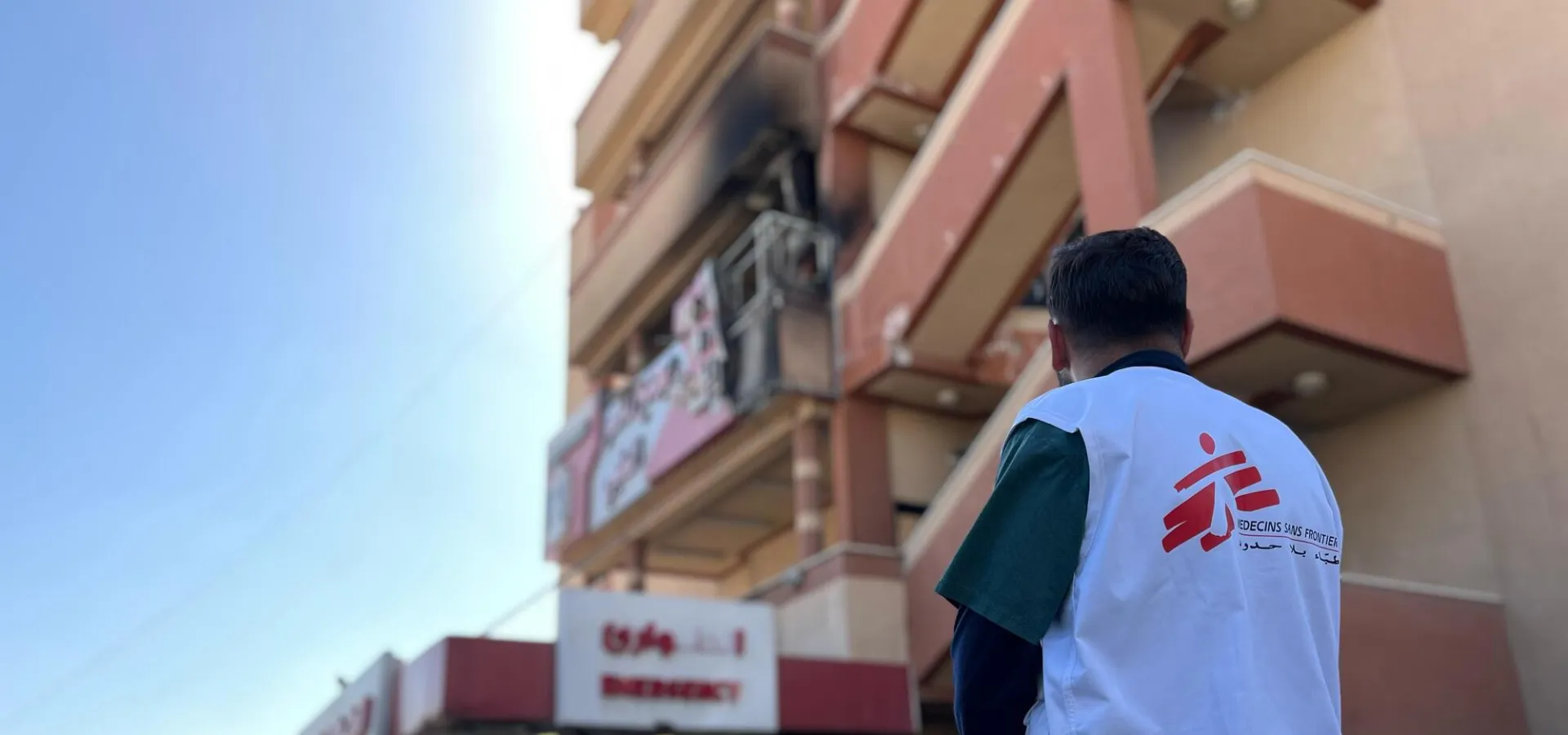 Zaměstnanec Lékařů bez hranic stojí před Násirovou nemocnicí po izraelském útoku v březnu 2025. Pásmo Gazy, 2025. Foto: Lékaři bez hranic