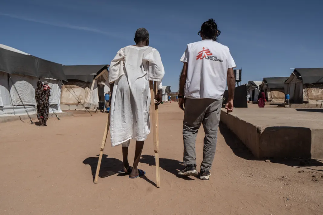 Zraněný muž a lékařský koordinátor Lékařů bez hranic před nemocnicí. Súdán, 2026. Foto: Giles Clarke
