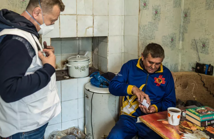Zdravotník pozoruje pacienta, který si bere léky, Ukrajina, 2021. Foto: Oksana Parafeniuk / Lékaři bez hranic
